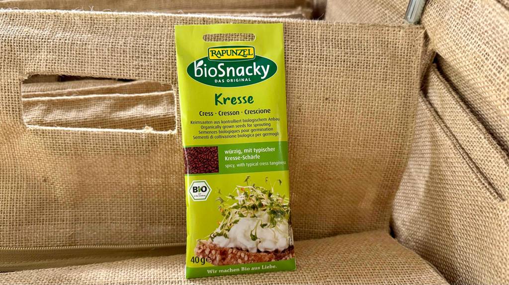Eine Packung Brunnenkresse-Samen steht zum testen in einem Jute-Korb.