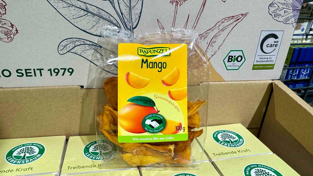 Getrocknete Mango im Test befindet sich in einer 100-g-Packung auf einem Karton im Lebensmittelgeschäft.