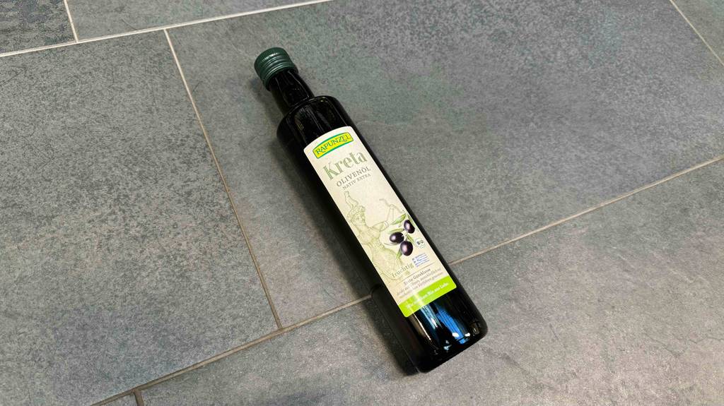 Eine Flasche Olivenöl Kreta liegt getestet auf einem Boden.