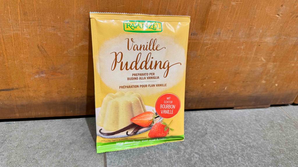 Im Test: Vanillepuddingpulver in der Tüte steht vor einer Holzfläche.