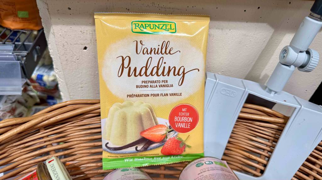 Getestet: Vanillepuddingpulver in der Tüte liegt in einem Korb mit Lebensmitteln.