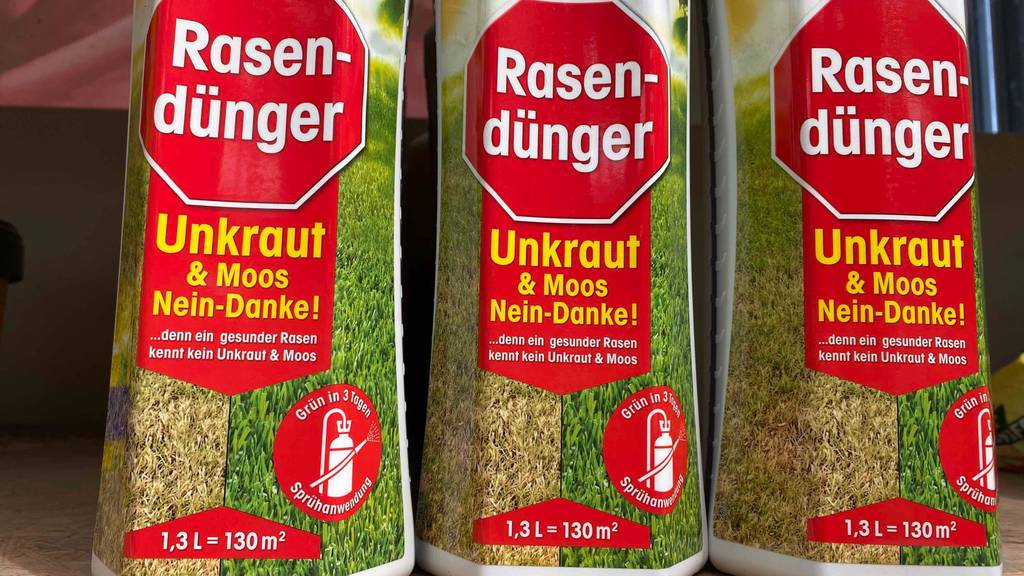 Drei getestete Flaschen mit Rasendünger in der Nahaufnahme.