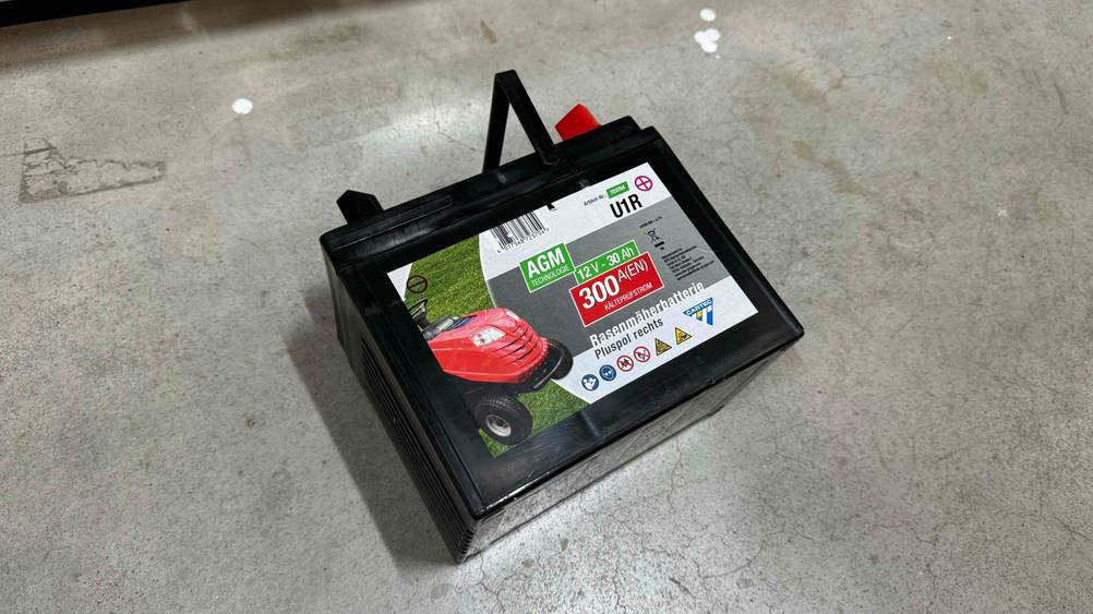 Rasentraktor-Batterie getestet: Ein Produkte von schräg unten auf einem Betonboden liegend.