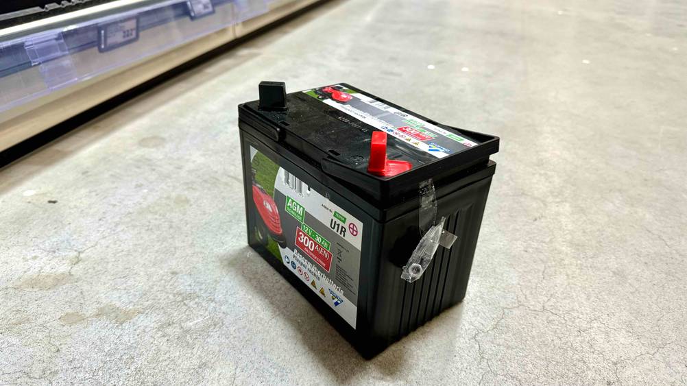 Getestet: Eine Rasentraktor-Batterie von schräg seitlich auf einem Betonboden stehend.
