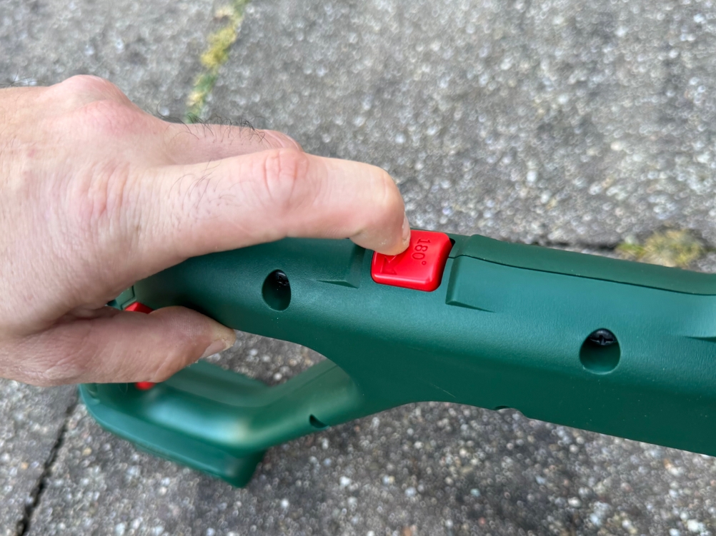 Detailansicht des Knopfes zum Drehen des Trimmerkopfes des getesteten Rasentrimmers von Bosch.