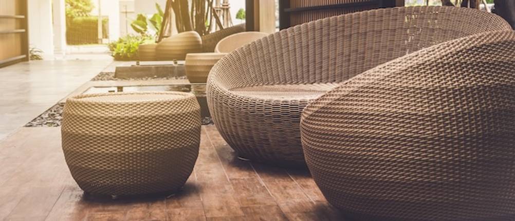 Zwei große, runde Rattansessel mit einem Rattantisch auf einer Holzterrasse im Test.