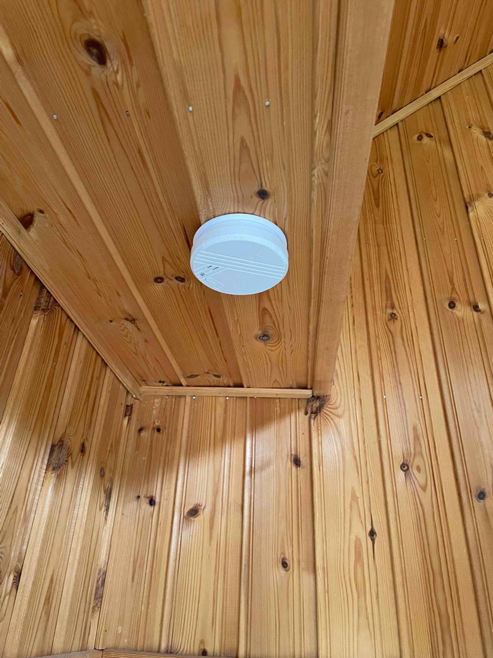Ein Rauchmelder von Biltema wurde an einer hölzernen Decke montiert.