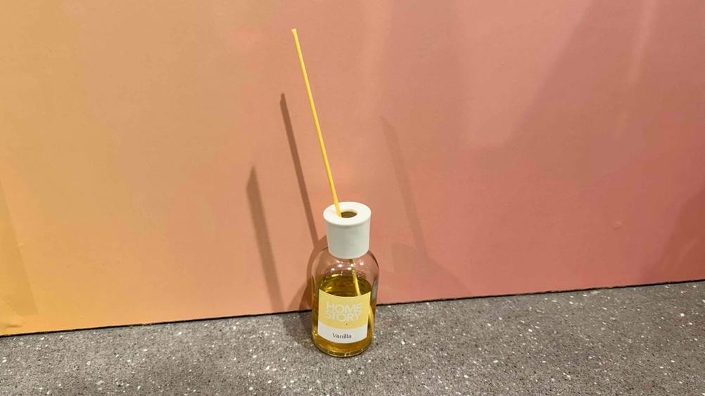 Getestet: Ein Raumduft Vanille steht vor einer rosa Wand auf dem Boden.