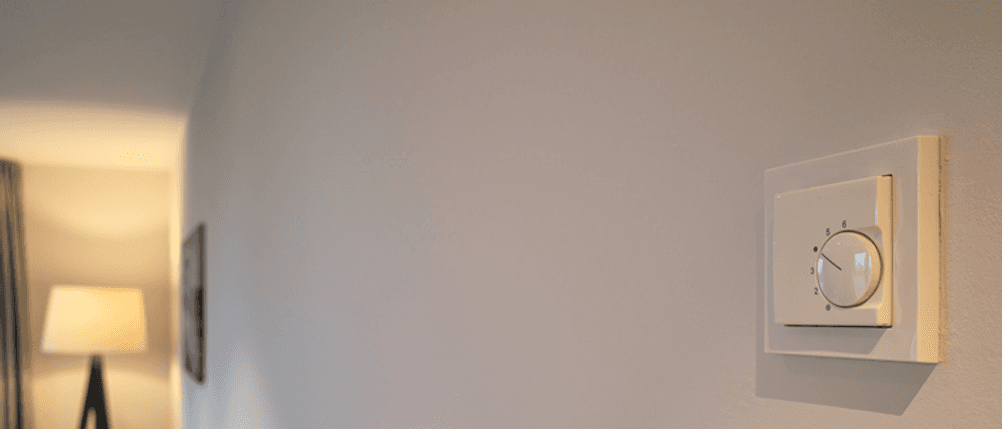 Raumthermostat für die Fußbodenheizung im Test: Ein Raumthermostat für die Fußbodenheizung hängt an einer Wand.