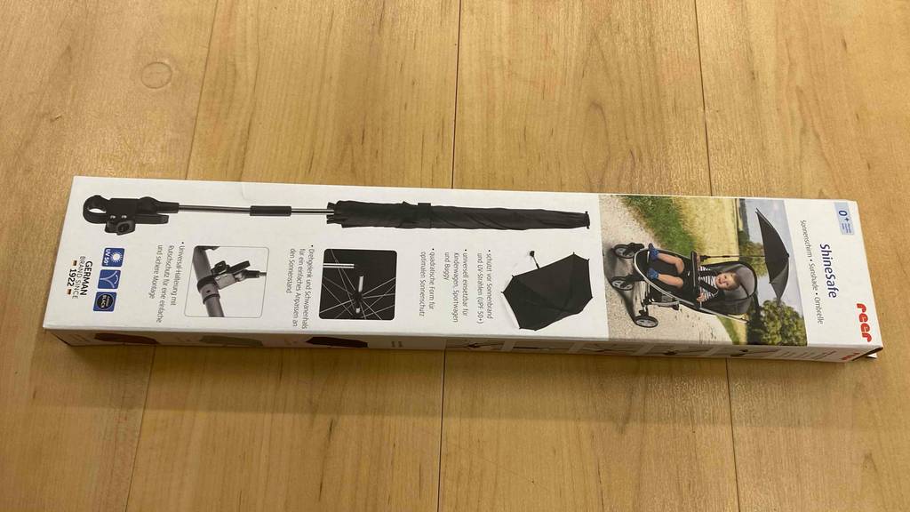 Sonnenschirm für den Kinderwagen getestet: Karton liegt auf dem Boden.