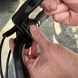 Eine Hand befestigt den Reezer RS1 auf der Halterung am Fahrradlenker.