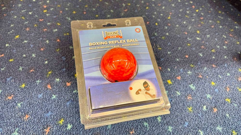 Ein getesteter Reflexball Boxen liegt auf einem Teppich.