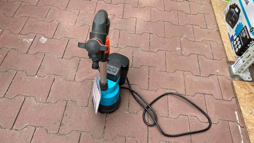 Auf dem Boden befindet sich eine getestete Regenfasspumpe.