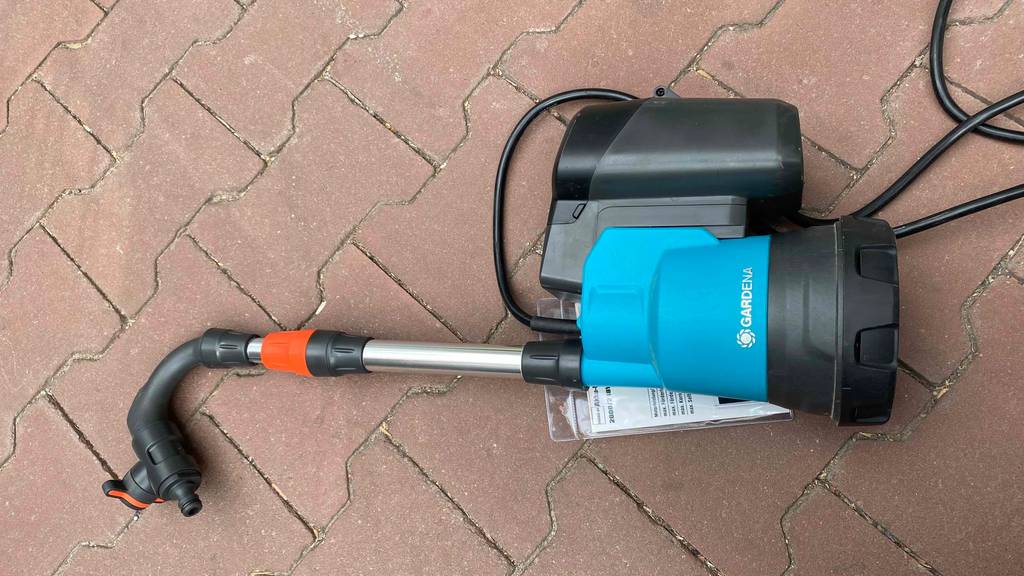 Auf dem Boden liegt eine getestete Regenfasspumpe. 