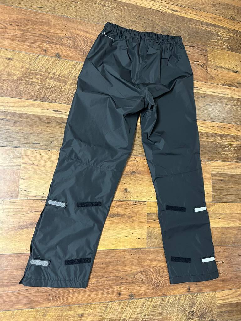 Auf dem Bild: die Regenhose von Vaude. Sie schützt angemessen vor Regen und Nässe.