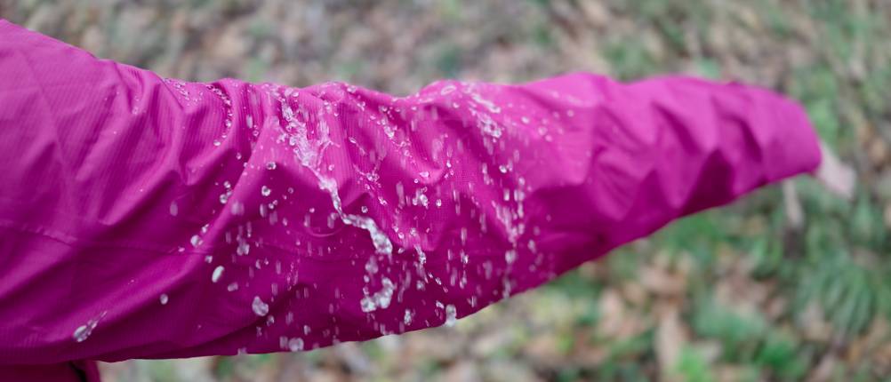 Regen perlt am Ärmel der pinkfarbenen 33,000ft Damen-Regenjacke ab.