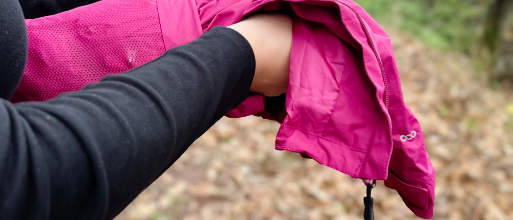 Die pinkfarbene 33,000ft Regenjacke wird aus ihrem Beutel geholt.