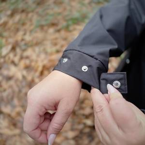 Der Ärmel der schwarzen Helly Hansen Damen-Regenjacke mit Knöpfen zur Weitenregulierung.