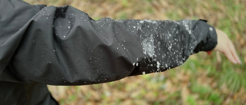 Regen perlt am Ärmel der schwarzen Helly Hansen Damen-Regenjacke ab.