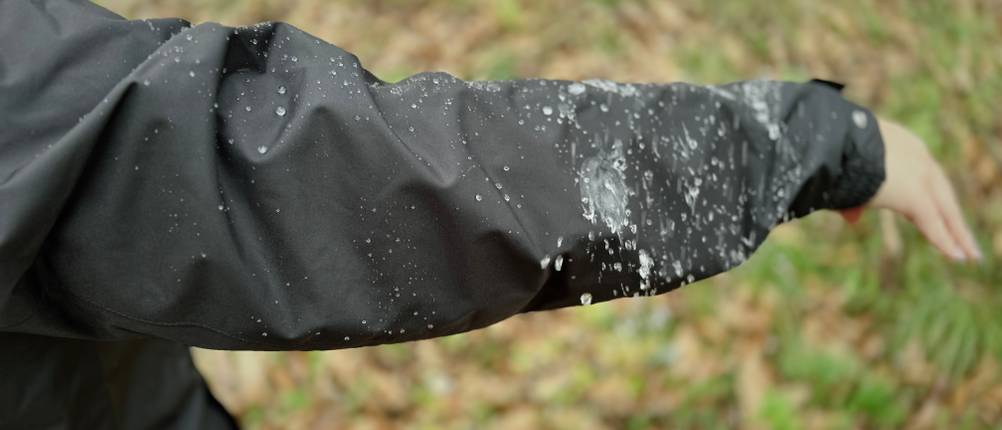 Regen perlt am Ärmel der schwarzen Helly Hansen Damen-Regenjacke ab.