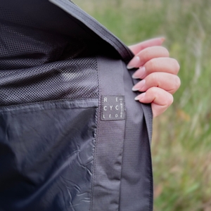 Die Innenseite der schwarzen Vaude Damen-Regenjacke mit einem Hinweis, dass der Innenstoff recycelt ist.