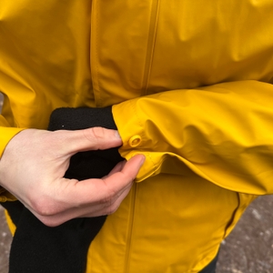 Nahaufnahme des Ärmelbundes der Helly Hansen Moss Regenjacke. Der Druckknopf ermöglicht eine individuelle Anpassung der Weite.