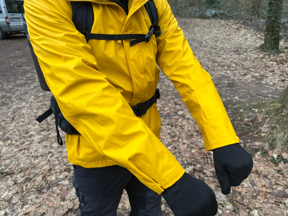 Die Helly Hansen Moss Regenjacke aus wasserdichtem PU-Material in Nahaufnahme. Die glatte Oberfläche reflektiert das Licht leicht.
