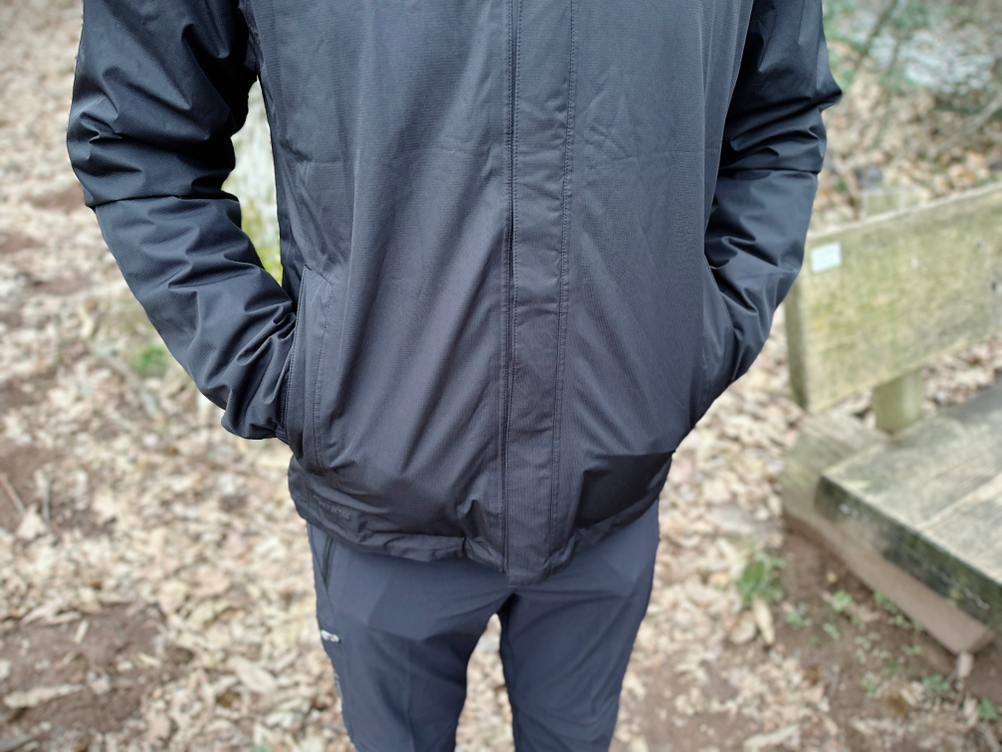 Die seitlichen Eingrifftaschen der Vaude Escape Light Regenjacke mit Reißverschlüssen. Eine Person steckt die Hände in die Taschen.