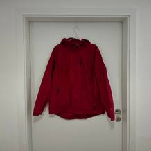 Die pinkfarbene 33,000 ft Damen-Regenjacke hängt an einem Kleiderbügel an einer weißen Tür.