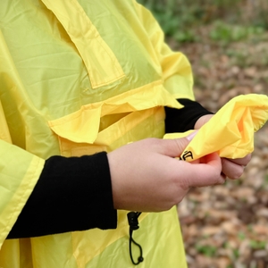 Der Regenponcho AWHA hat eine breite Bauchtragetasche, in der man den Beutel verstauen kann.