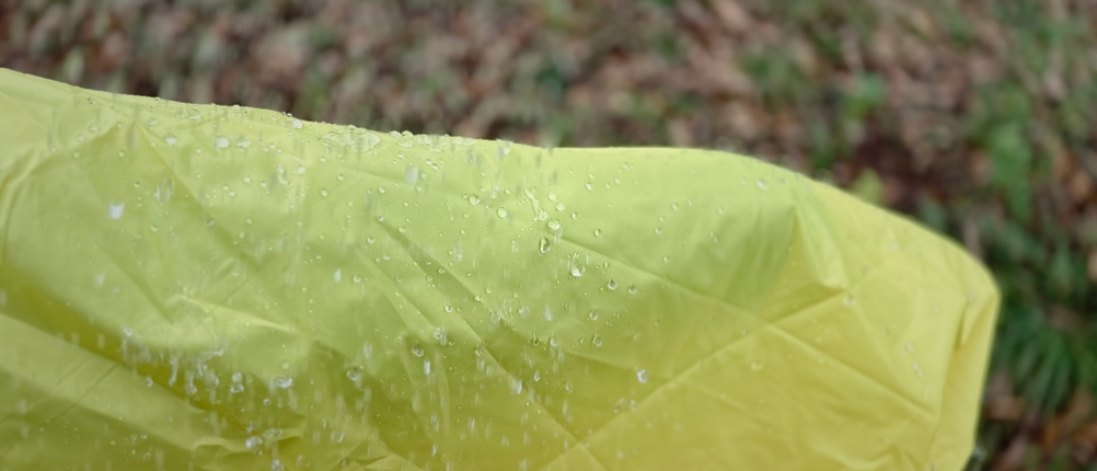 Der AWHA-Regenponcho zeigt seine guten Abperleffekte unter dem Regen. 