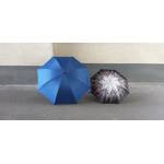 Ein großer und ein kleiner Regenschirm liegen aufgespannt nebeneinander.