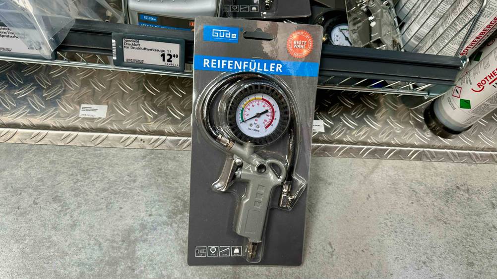 Reifenfüller getestet: Ein transparent verpacktes Gerät lehnt an einem Verkaufsregal.