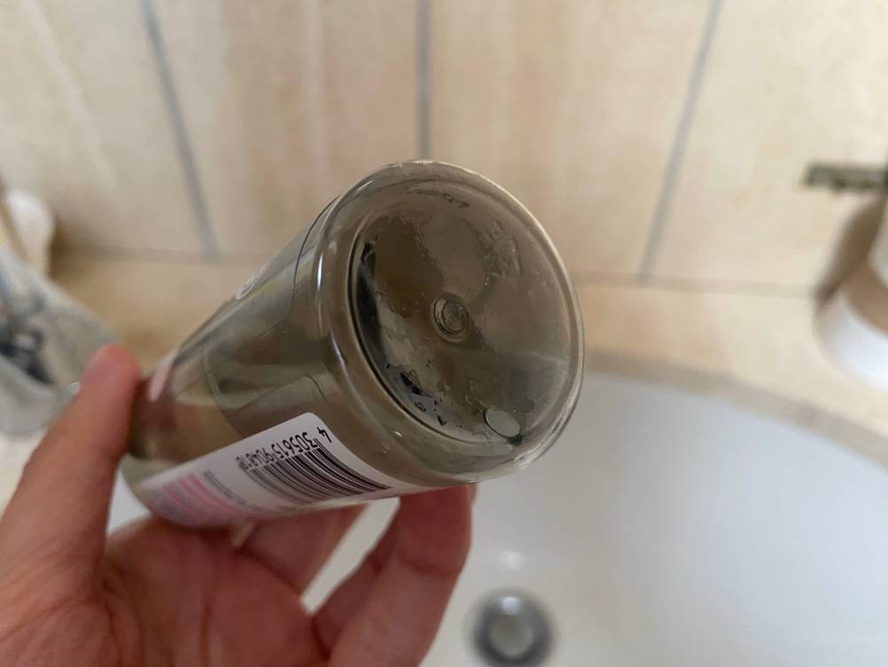 Eine Hand hält ein getestetes Reinigungsöl für das Gesicht.