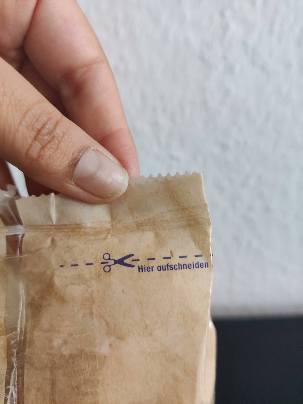Nahaufnahme des Aufdrucks 'hier aufschneiden' an einer Packung Reis im Test.