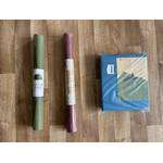 Reise-Yogamatten im Test: Drei eingepackte Matten auf dem Boden.
