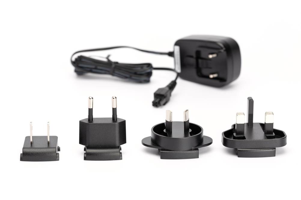 Reiseadapter-USA im Test: Ein Set aus verschiedenen Adaptern mit einem Netzteil, alle in Schwarz, auf weißem Hintergrund.
