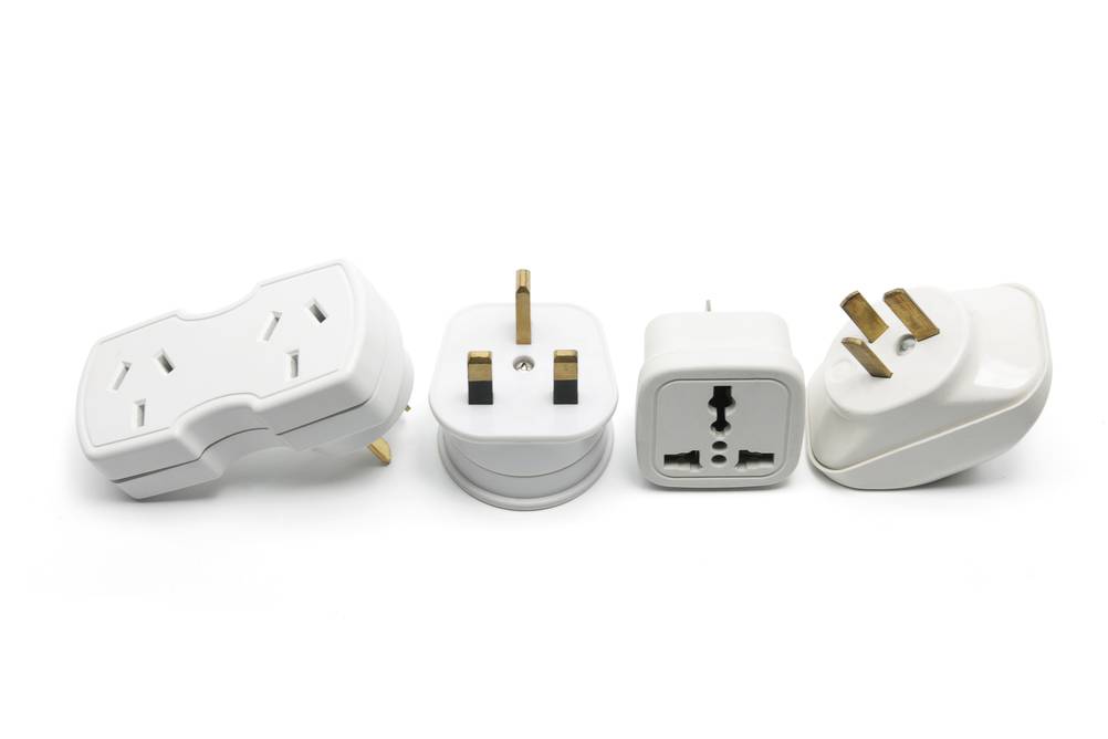 reiseadapter-usa im Test: vier Adapter auf weißem Grund