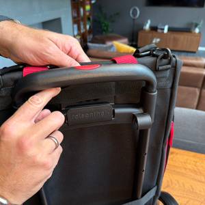 Eine Hand befestigt die Tasche vom Reisenthel DF7003.