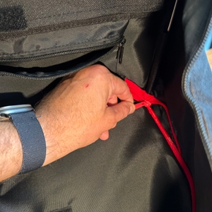 Eine Hand schließt einen Reißverschluss im Reisenthel DF7003.