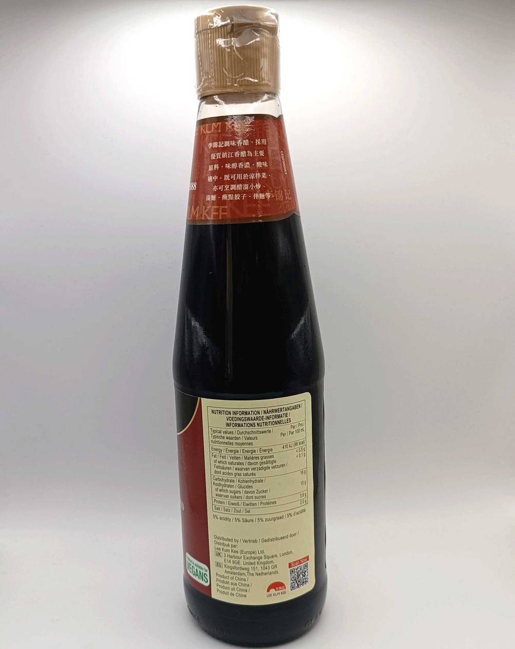 Seitenansicht einer getesteten Flasche Reisessig vor einer hellen Fläche.