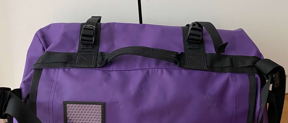 Eine Reisetasche steht auf dem Boden.