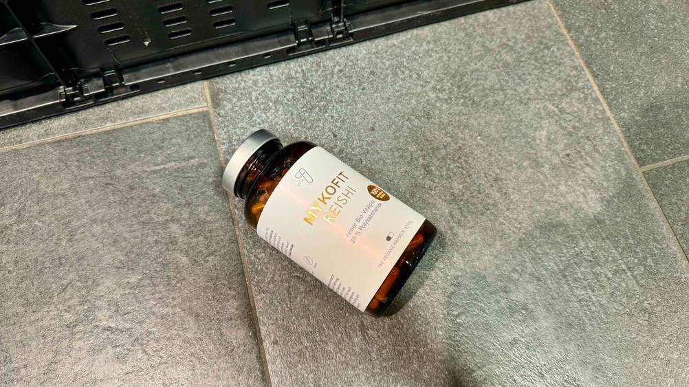 Reishi-Kapseln getestet: Eine Flasche liegt leicht schräg auf einem Fließenboden.
