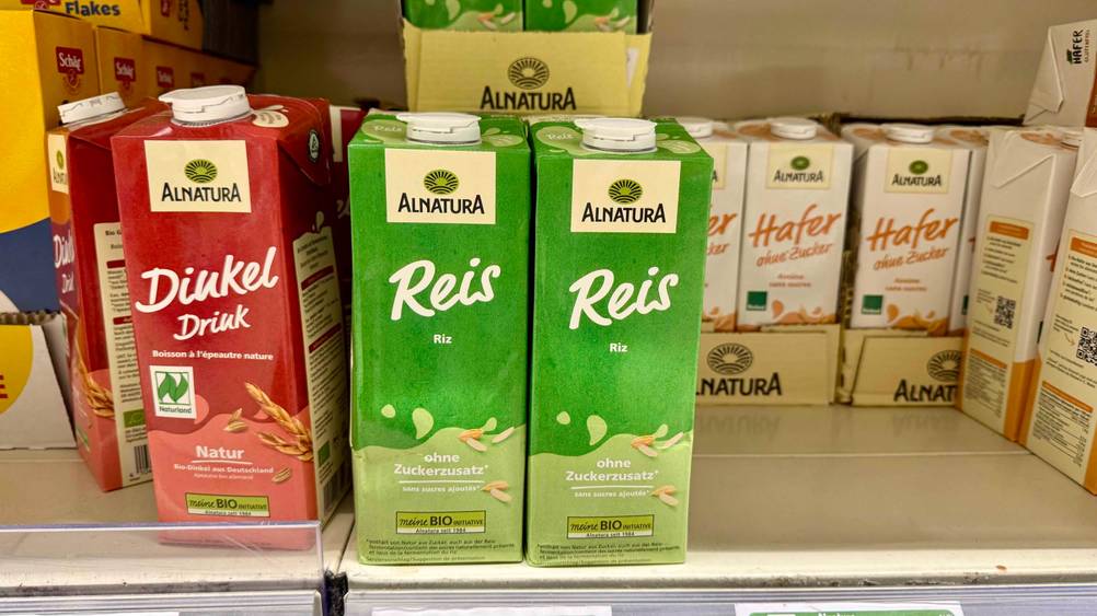 Mehrere Packungen der Reismilch im Test in einem Verkaufsregal neben anderen Produkten.