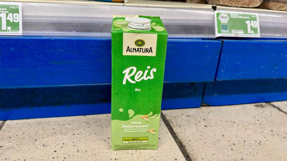 Vor einem Regal auf dem Boden steht die getestete Reismilch.