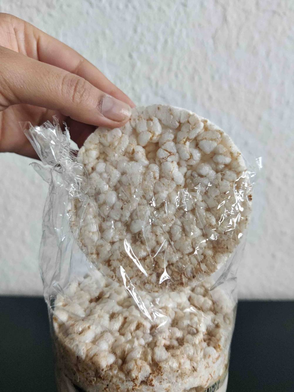 Eine getestete Reiswaffel wird aus der Verpackung genommen. 