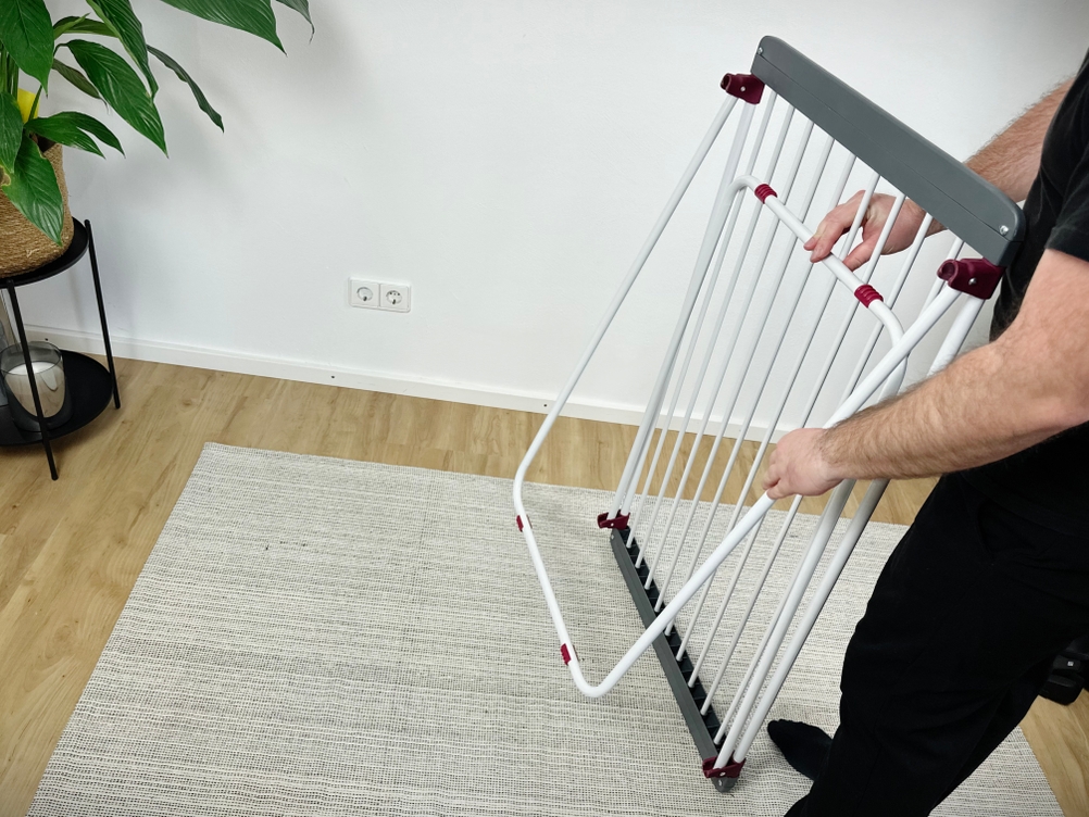 Eine Person klappt den Relaxdays 10018866 in aufrechter Haltung auseinander. Die Leinen sind noch zusammengefaltet.