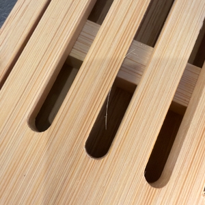 Von der Produktion stehen kleine Holzteile vom Relaxdays-Brotschneidebrett ab