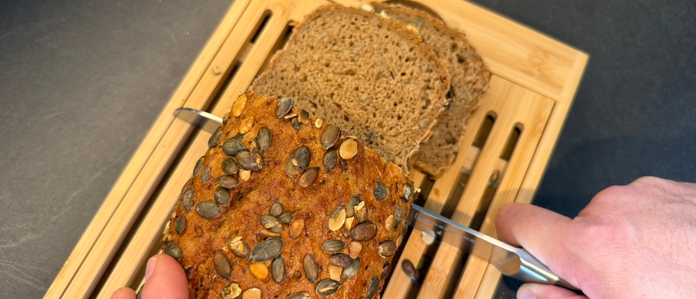 Ein Brot wird auf dem Relaxdays-Brotschneidebrett geschnitten
