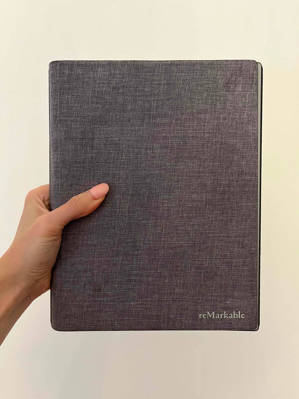 Im Test: Hand hält ein reMarkable Tablet mit 11 Zoll vor weißer Wand.